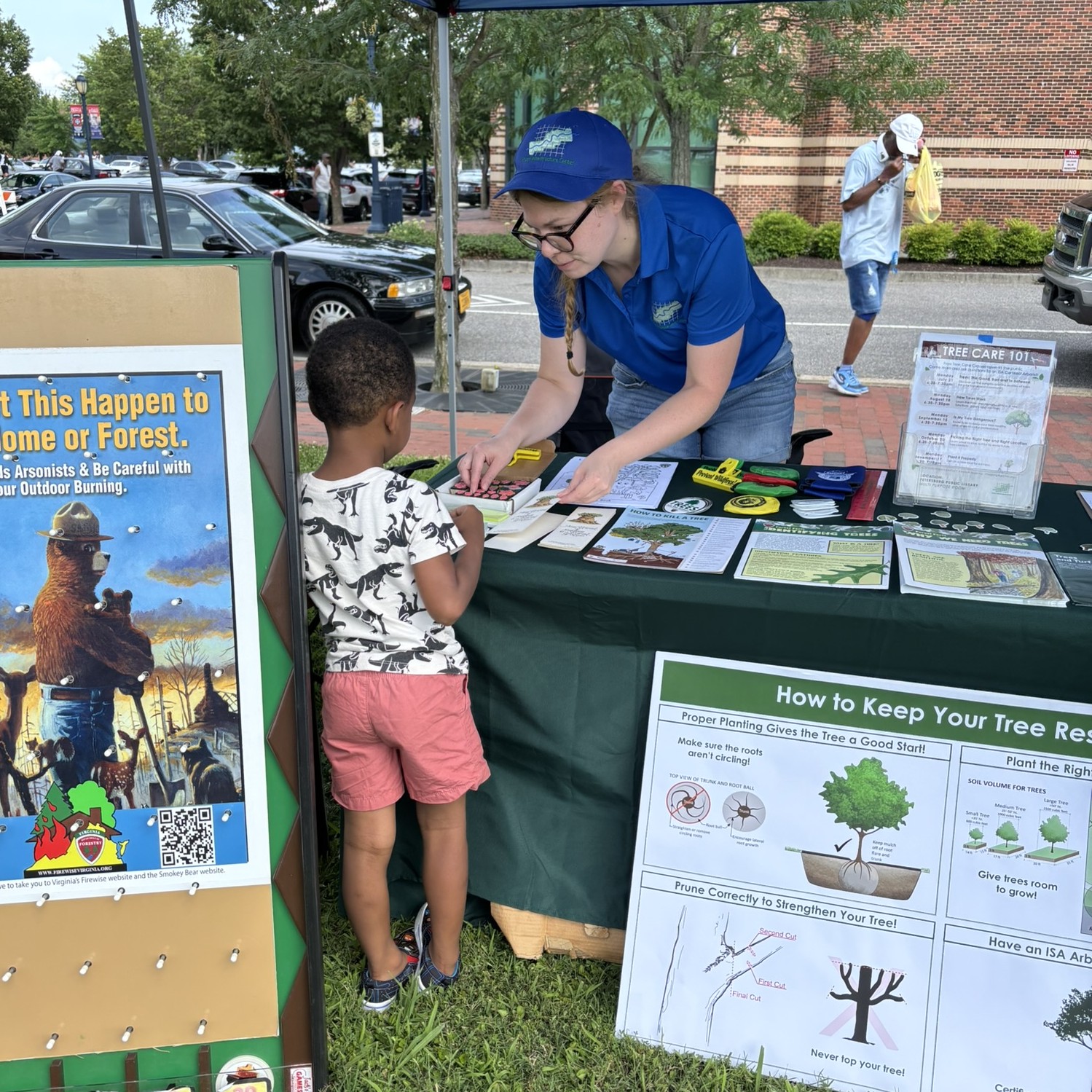 A GIC staff member shares educational materials on trees at their outreach table during a community event in Hopewell.